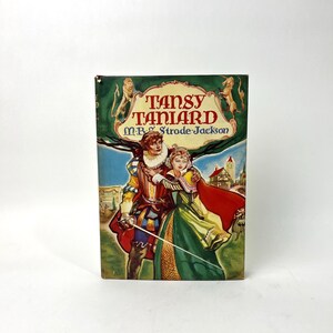 May include: A vintage book titled "Tansy Taniard" by M.B. Strode-Jackson. The cover features a colorful illustration of a man and woman in period clothing, with a castle in the background. The book has a green and gold banner at the top.
