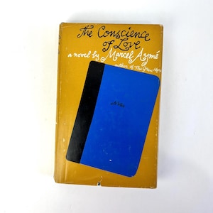 May include: A yellow book cover with black and blue accents. The title is "The Conscience of Love" by Marcel Aymé, author of "The Green Mare".