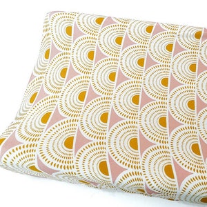 May include: A pink and gold changing pad cover with a geometric pattern of overlapping circles.
