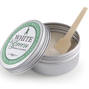 May include: A silver tin of White & Green mineral toothpaste with a wooden spatula. The label reads "Naturally Whitening White & Green Mineral Toothpaste Removes Stains 95g e".