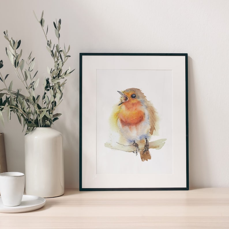 May include: A watercolour painting of a robin perched on a branch, singing with its beak open. The bird is painted in shades of orange, red, and brown, with a white chest and blue tail feathers. The background is a soft white.