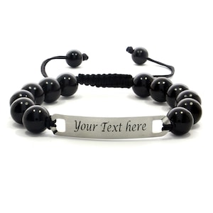 Op de afbeelding: Zwarte kralen armband met een zilveren plaat waarop "Your Text here" staat.