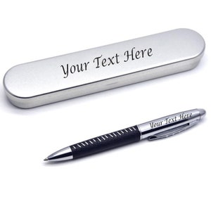 Puede incluir: Un bolígrafo y una caja plateados con detalles negros. El bolígrafo y la caja están grabados con el texto "Your Text Here".