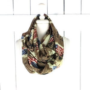 Puede incluir: Una bufanda infinita marrón con un patrón de banderas americanas y un diseño de camuflaje.