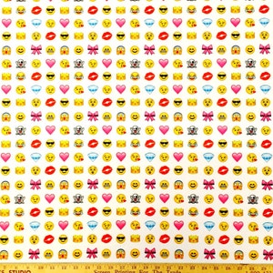 May include: White fabric with a repeating pattern of yellow smiley faces, red lips, pink bows, white diamonds, and red hearts.
