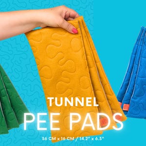 Può includere: Tre traverse per tunnel piegate, verdi, gialle e blu, ciascuna tenuta da una mano. I cuscinetti hanno un motivo trapuntato e misurano circa 36 cm di lunghezza e 16 cm di larghezza. Il testo "TUNNEL PEE PADS" è visualizzato.