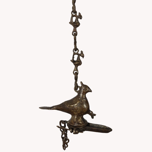 Antica lampada a olio sospesa in bronzo fuso a forma di bellissimo mitico uccello pavone con catena sospesa.