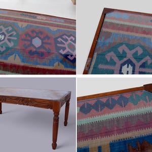 May include: A wooden coffee table with a glass top featuring a colorful patterned rug design. The table has a carved wooden base and four legs.