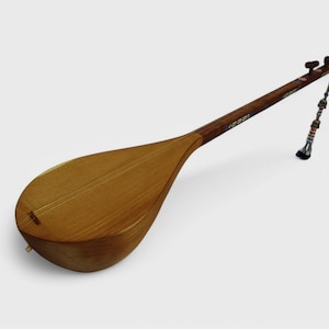 May include: A wooden tan-colored tanbur, a long-necked lute with a pear-shaped body, with a dark brown neck and a decorative string attached to the top.