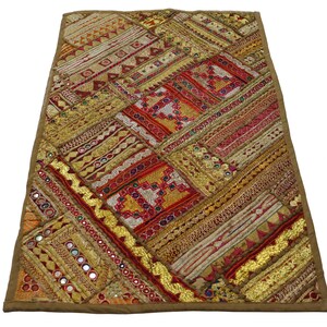 May include: A colourful patchwork wall hanging with gold, red and orange embroidery and mirror accents.