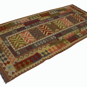 Könnte beinhalten: Rechteckiger Teppich mit geometrischem Muster in Braun-, Rot-, Grün- und Blautönen. Der Teppich hat ein zentrales Design mit sich wiederholenden Formen und einen Rand mit Fransen. Der Teppich besteht aus gewebtem Material.