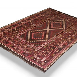 May include: A traditional red and brown rug with a geometric pattern. The rug has a fringe border and is made of wool.