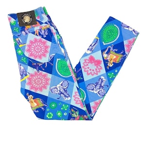 May include: Blue jeans with a vibrant pattern featuring elephants, floral designs, and paisley shapes. The jeans have a leather patch with the Versace Jeans Couture logo. The overall design is a patchwork of blue, pink, and green.