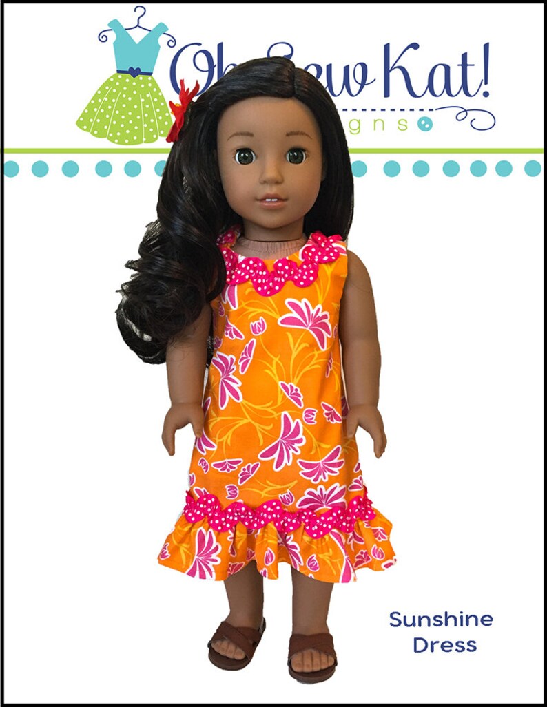 May include: A doll wearing a bright orange and pink floral dress with a ruffled hem. The dress has a pink polka dot trim. The doll has brown skin and long dark hair. The text "Sunshine Dress" is at the bottom of the image.