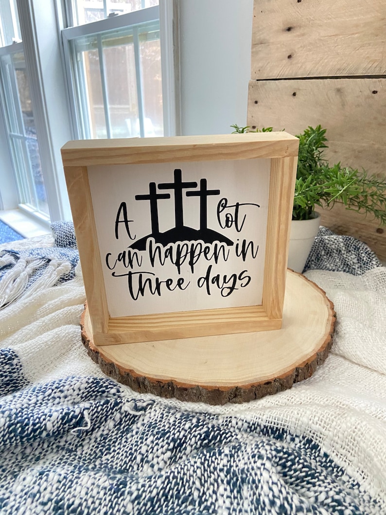 Puede incluir: Un letrero de madera con fondo blanco y letras negras. El letrero dice "Mucho puede pasar en tres d&iacute;as" y tiene tres cruces negras sobre el texto.