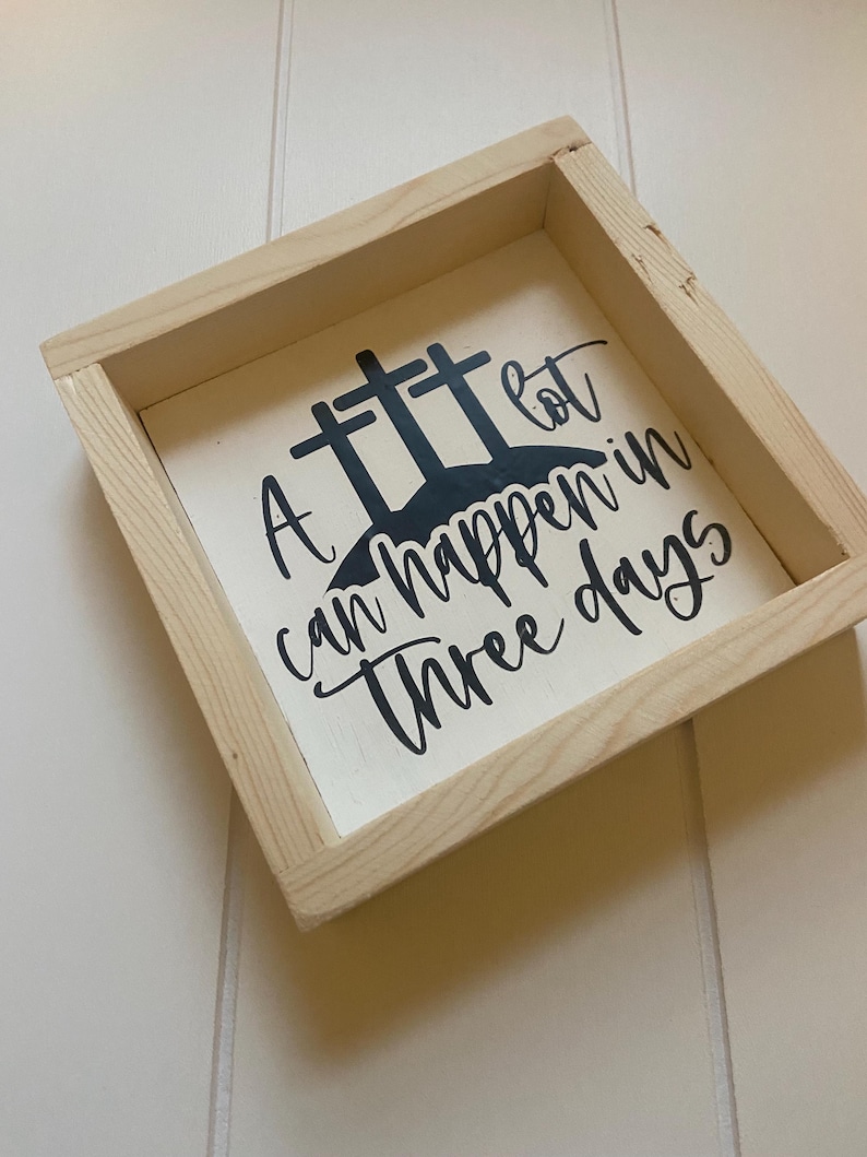 Puede incluir: Un letrero de madera con fondo blanco y letras negras. El letrero dice "Mucho puede pasar en tres d&iacute;as". Hay tres cruces negras detr&aacute;s del texto.