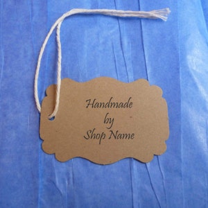 May include: A brown paper tag with a white string attached. The tag has the text "Handmade by Shop Name" written on it.