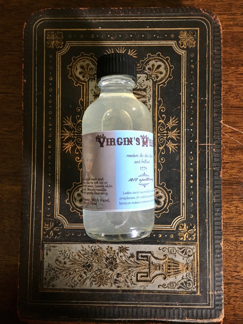 May include: A clear glass bottle with a black cap and a white label that reads "VIRGIN'S MILK renders the skin soft and beautiful 1779 1812 apothecary Ladies use it naturally for a clear complexion, for which purpose it is better, or indeed to make it whiter."