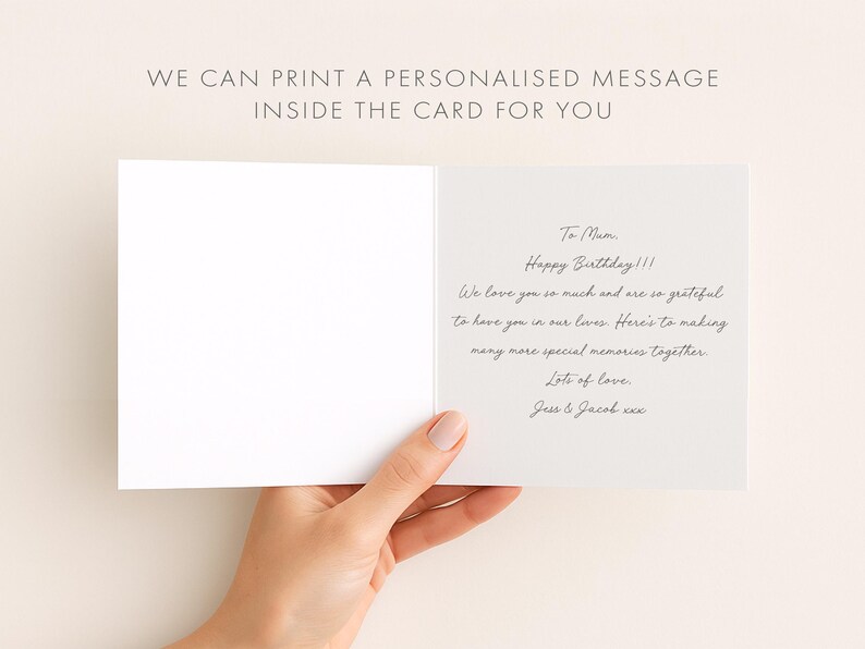 A hand holding an open birthday card with a personalized message inside.