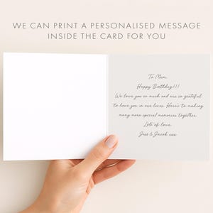 A hand holding an open birthday card with a personalized message inside.