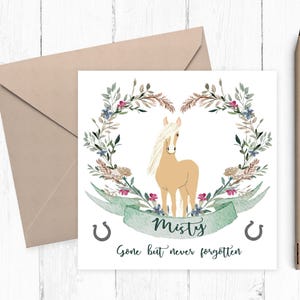 May include: A square greeting card featuring a tan horse with a white mane centered within a watercolor floral wreath. A green banner below the horse displays the name Misty, flanked by two horseshoes, with the text Gone but never forgotten.