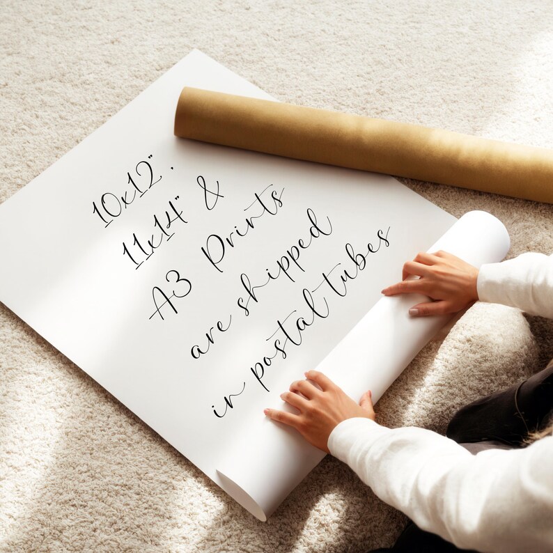 A person is holding a roll of paper and appears to be preparing to print or roll it.