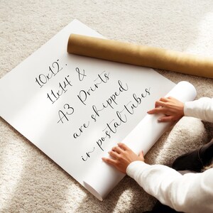 A person is holding a roll of paper and appears to be preparing to print or roll it.