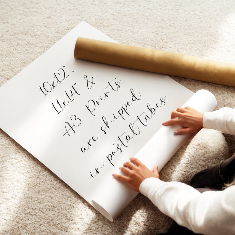 A person is holding a roll of paper and appears to be preparing to print or roll it.