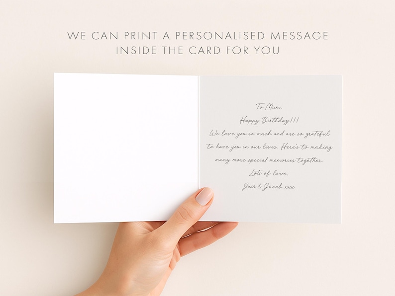A hand holding an open birthday card with a personalized message inside.