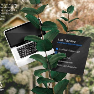 Puede incluir: Tarjeta de visita cuadrada negra con texto blanco. El texto dice "Lea Caballero, Estratega de Dise&ntilde;o Creativo" e incluye informaci&oacute;n de contacto: correo electr&oacute;nico, n&uacute;mero de tel&eacute;fono, sitio web y un enlace a un sitio de redes profesionales. La tarjeta est&aacute; en una rama verde con hojas.