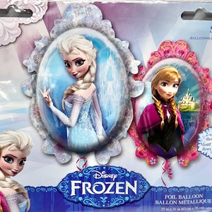 May include: A foil balloon featuring characters from Disney's Frozen. The balloon has two sides with different images of Elsa and Anna. The balloon is 25 inches by 31 inches.