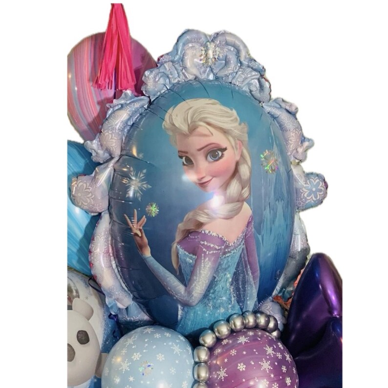 May include: A collection of colorful balloons, including a large, oval-shaped balloon featuring a portrait of Elsa from the movie Frozen. The balloons are in shades of blue, purple, and pink, with snowflake and floral patterns.