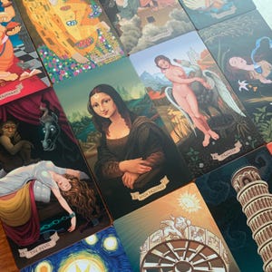 May include: A set of tarot cards with colorful illustrations. The cards feature images of the High Priestess, The Lovers, Strength, The Devil, and The Tower. The cards are arranged in a grid pattern.