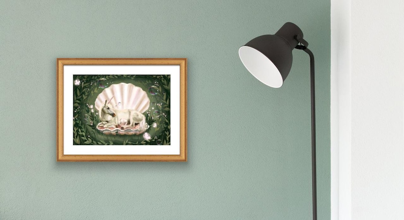 May include: A white rabbit and a baby rabbit are nestled inside a large, pearl-coloured seashell. The shell is surrounded by green leaves and white flowers.