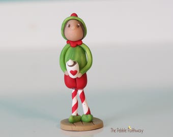 Elfo navideño de cabello castaño con chocolate caliente