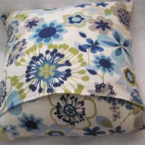 May include: Square decorative pillow with a floral pattern in shades of blue, green, and gray on a cream background. The pillow features a repeating design of stylized flowers.
