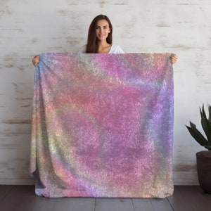 May include: A soft, plush throw blanket with a colorful iridescent pattern. The blanket has a subtle shimmer and a textured surface.