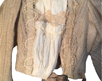 May include: A beige jacket with a lace trim and a matching beige ribbon tied at the waist. The jacket has a high collar and long sleeves.