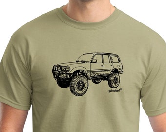 Könnte beinhalten: Ein khakifarbenes T-Shirt mit einer schwarzen Strichzeichnung eines Land Cruiser SUV mit großen Reifen. Der Text "got cruiser?" ist unter dem Fahrzeug aufgedruckt.