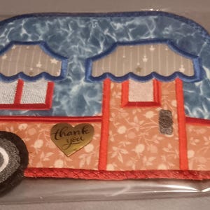 May include: A red, white and blue fabric camper van applique with a gold heart that says "Thank You".