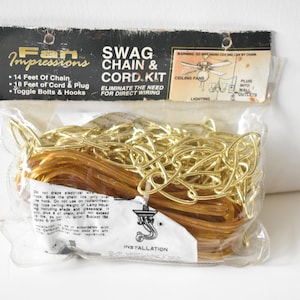 May include: A package containing a gold swag chain and cord kit for ceiling fans. The package includes 14 feet of chain, 18 feet of cord, a plug, toggle bolts, and hooks. The package is labeled "Fan Impressions Swag Chain & Cord Kit".