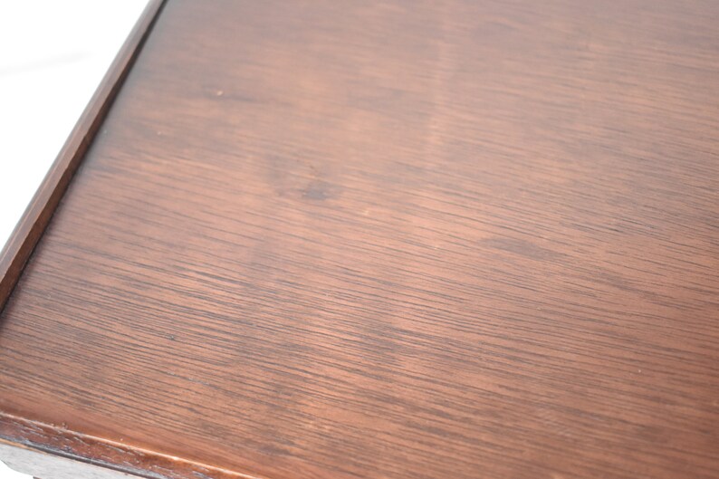 Pode incluir: Close-up de um tampo de mesa de madeira marrom escuro com uma superf&iacute;cie lisa e ligeiramente texturizada.