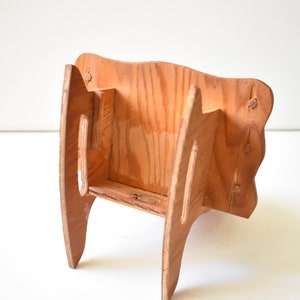 May include: A wooden shelf unit with a simple design. The shelf is made of light brown wood and has a rectangular shape. The shelf has two shelves and is supported by two legs on each side.