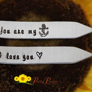 May include: Two silver tie clips with engraved messages. The top clip reads "You are my" with a small anchor symbol. The bottom clip reads "I love you" with a heart symbol.