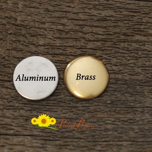 May include: Two round metal discs, one silver and one gold, with the words "Aluminum" and "Brass" printed on them.
