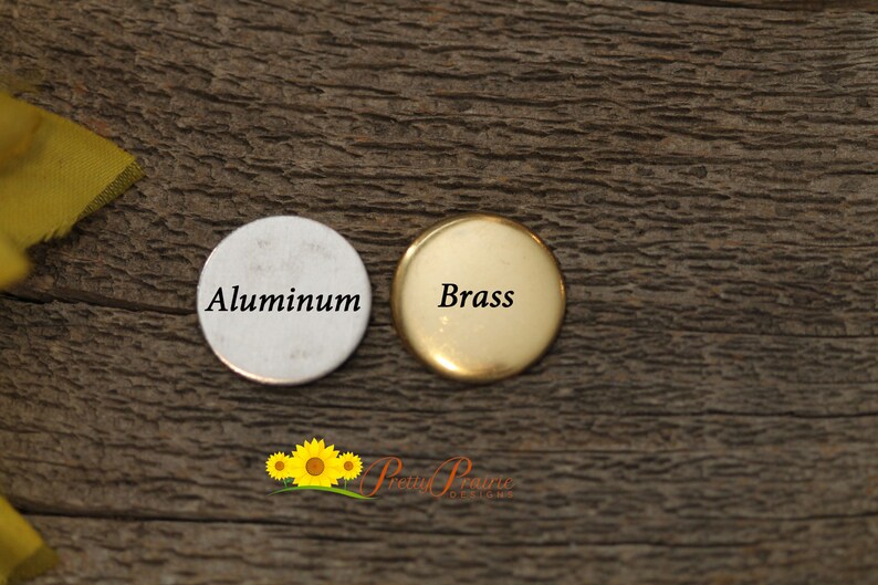 May include: Two round metal discs, one silver and one gold, with the words "Aluminum" and "Brass" printed on them.