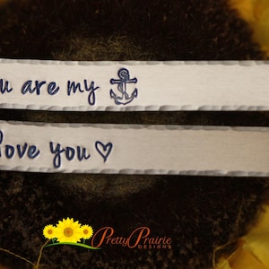 May include: Two silver metal tags with a hammered finish. The top tag says "You are my" with a blue anchor symbol. The bottom tag says "I love you" with a heart symbol.
