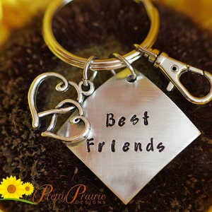 May include: Silver keychain with two intertwined hearts and a silver tag that says "Best Friends".