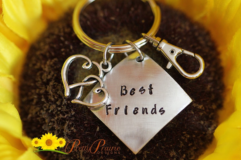 May include: Silver keychain with two intertwined hearts and a silver tag that says "Best Friends".
