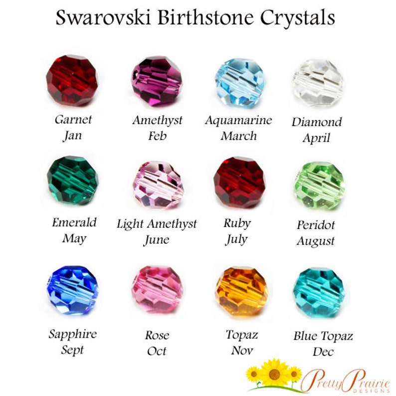 May include: A chart of Swarovski birthstone crystals, showing a different crystal for each month of the year. The crystals are arranged in three rows of four, with the month and birthstone name listed below each crystal. The crystals are all faceted and have a shiny, polished finish.
